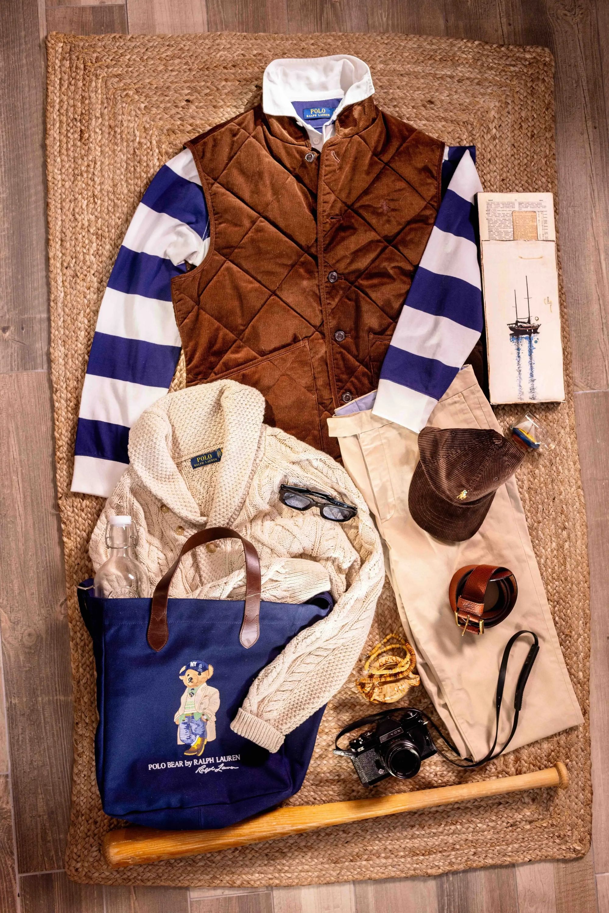 HANK quilted vest, knitwear and weekend essentials arranged on a table